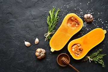 Halves of raw organic butternut squash with spices and ingredients for making.Top view with copy...