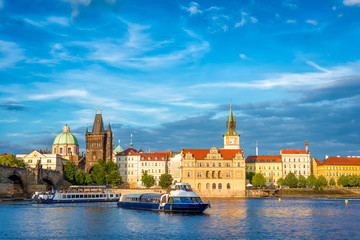 Naklejka premium Sightseeing cruise boat on Vltava river with Charles Bridge on background. Prague, Czech Republic