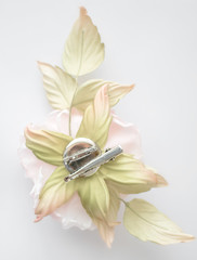 Back side of hand made flower rose on white blurred background with pin for fastening. Vintage...