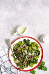 Spinach tagliatelle with mushrooms and cream.Top view with copy space.
