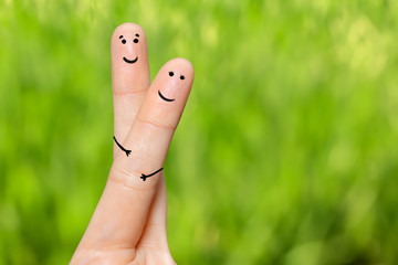 Human hand fingers with funny painted emoticons. People relationships concept