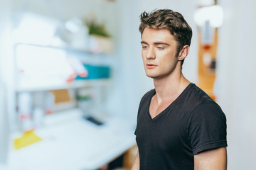 Puzzled thoughtful young man curiously looking at camera