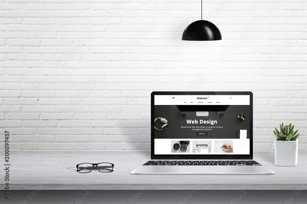 Poster Laptop with modern web site presentation. Free space for text beside on white brick wall.