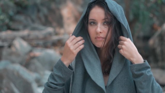 Mysterious beautiful woman with make up puts on her hood