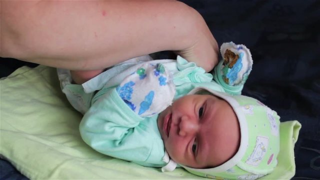 Mother Changing Babies Clothes,the mother replaces the infant dummies on the bed