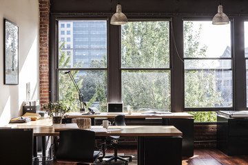 Creative office interior. View through a window to trees and city buildings. 