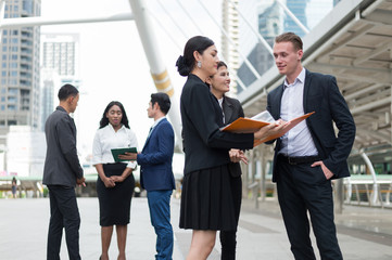 Group of business people standing in the city and discussing ideas for business future. multi culture of business people, African, Caucasian and Asian.