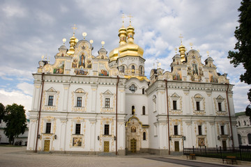 Fototapeta na wymiar Medieval Cathedral of the Dormition on a background of sky with clouds in springtime. National Historic Cultural Sanctuary Kyiv Pechersk Lavra, Kiev, Ukraine