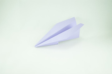 Violet paper plane on a white background, isolated. Concept (idea) of airlines, freedom, leadership, success,  and creativity. Close-up
