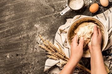 Baking - hands kneading the raw dough (pastry) in a bowl