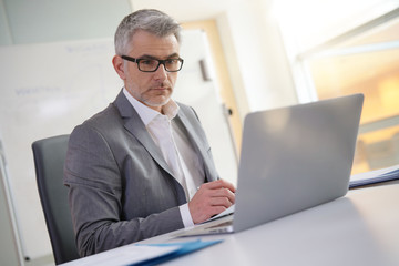 Businessman in office working on laptop