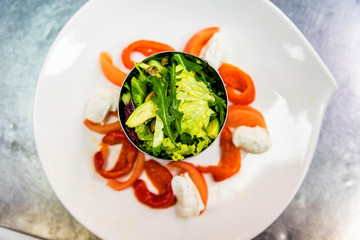 Making salad on white plate at cooking workshop