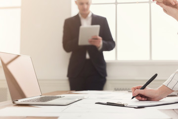 Male and female managers working on financial papers at modern office interior