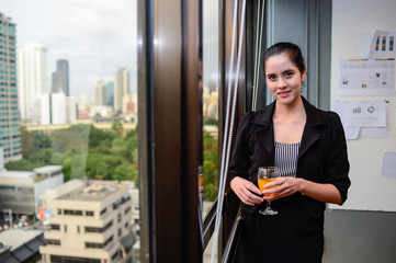 smile of beautiful business woman at the window with champagne