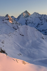 Sunset over the beautiful mountain peaks of the snowy Swiss Alps