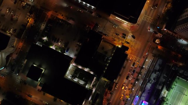 Aerial over city facing down tilt up reveal night