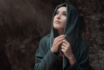 Beautiful young sexy girl with bright make-up in a grey hood