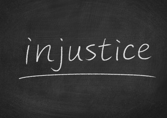 Obraz premium injustice concept word on a blackboard background