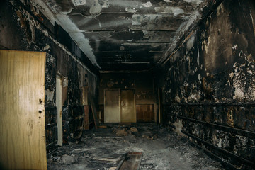Burned by fire interior of building. Charred corridor 