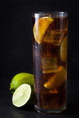 Cuba libre. Cocktail with rum, lime and ice on black background