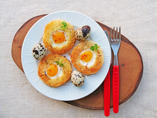Egg in a basket with quail eggs and saffron  on white plate