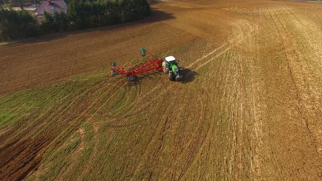 Tractor plowing a agricultural field - Tractor cultivating arable land for seeding crops, aerial view - 4K UHD - germany