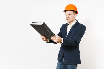 Irritated dissatisfied businessman in dark suit, protective construction helmet holding black folder for papers document isolated on white background. Male worker for advertisement. Business concept.