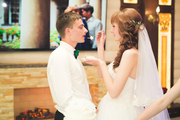 Naklejka premium Bride and groom at wedding cutting the wedding cake