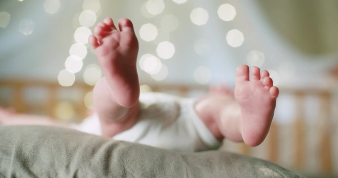 4k, newborn baby's legs close-up, High-key shot slow motion beautiful bokeh background
