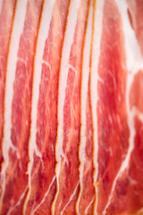 Sliced italian prosciutto background. Top view, copy space. Prosciutto texture close up.
