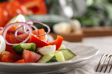 fresh vegetable salad with quail eggs in pink plate on the table
