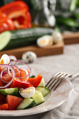 fresh vegetable salad with quail eggs in pink plate on the table