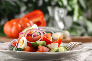 fresh vegetable salad with quail eggs in pink plate on the table