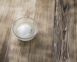 Mozzarella on a plate on a wooden background.