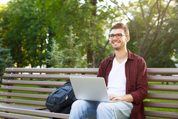 Fototapeta premium Happy young man with laptop outdoors