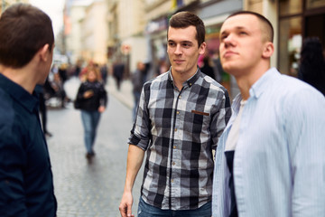 Three man talk on the street about business