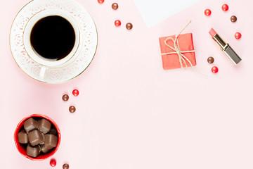 Cup of coffee, chocolate sweets, gift box flat lay. Feminine background.