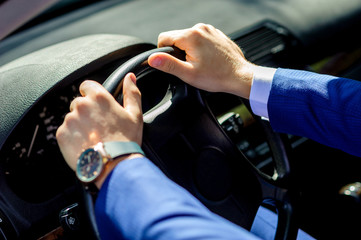 Driving a car, hands lie on the steering wheel.