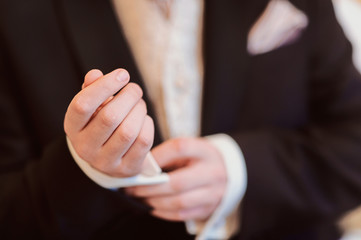 Obraz premium the groom adjusts his jacket, groom in a jacket, The morning of the groom