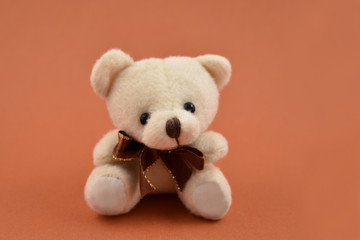 Teddy bear toy stock images. Teddy bear on a brown background. Brown teddy bear with ribbon