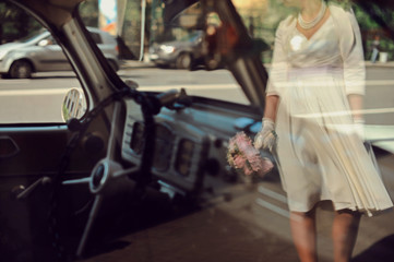 Obraz na płótnie Canvas Reflection of happy bride with bouquet in retro car window. Wedding newlywed marry me concept