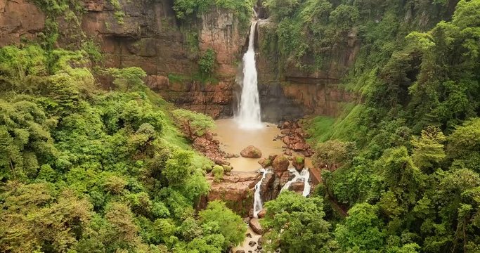 Beautiful aerial landscape of Cimarinjung waterfall and tropical jungle from a drone flying from right to left at Ciletuh Geopark, Sukabumi, West Java, Indonesia. Shot in 4k resolution