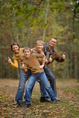Fototapeta premium Family in autumn forest with thumbs up
