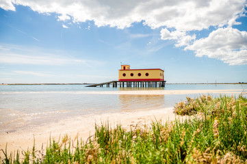 Sunny beach view of the historical life-guard building in Fuseta, Ria Formosa Natural park, Portugal