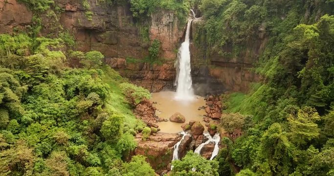 Beautiful aerial footage of Cimarinjung waterfall and tropical forest from a drone flying forward at Ciletuh Geopark, Sukabumi, West Java, Indonesia. Shot in 4k resolution