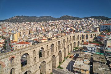 Aerial view the city of Kavala in northern Greek, ancient aqueduct Kamares, homes and medieval city wall