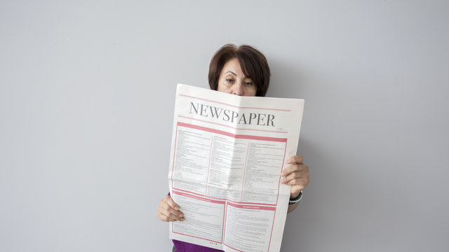 Woman reading the newspaper on wall