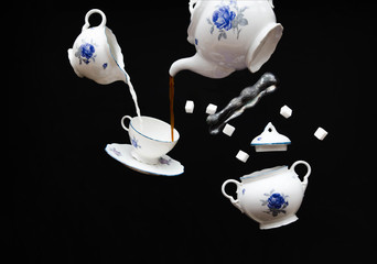 Flying porcelain coffee set - ghost tea party on black background