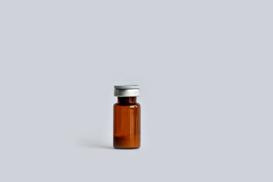 A vial (ampoule, container) with a drug (medicine powder) on a white background.