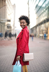 Pretty girl walking in the city with shopping bags